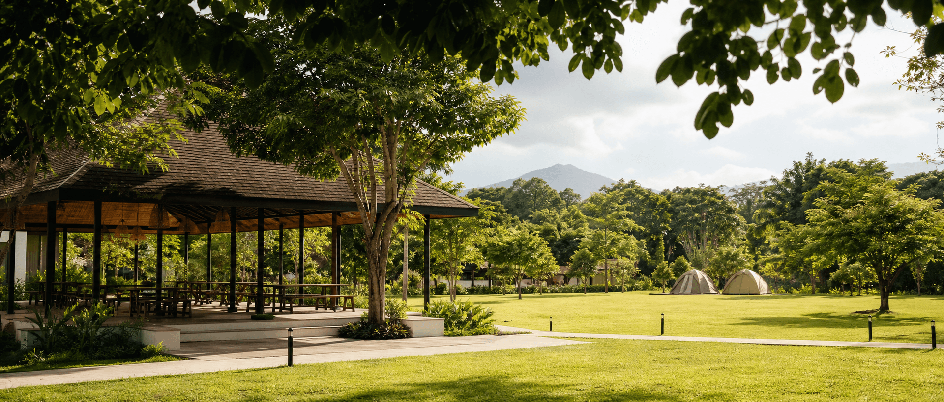 A green agro-tourism park with a pavilion and open campsite lawn